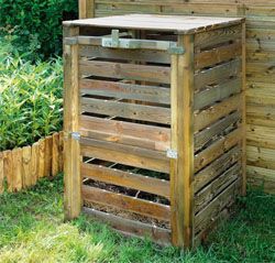 Bac à compost en bois dans une cour gazonnée.