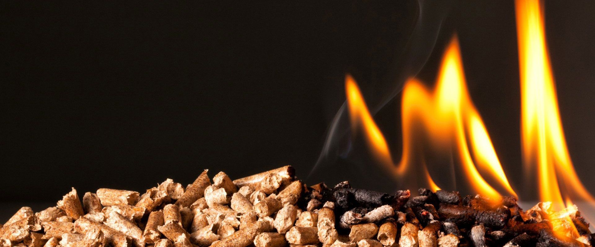 Tas de granulés de bois avec des flammes, passant du brun clair au noir brûlant.