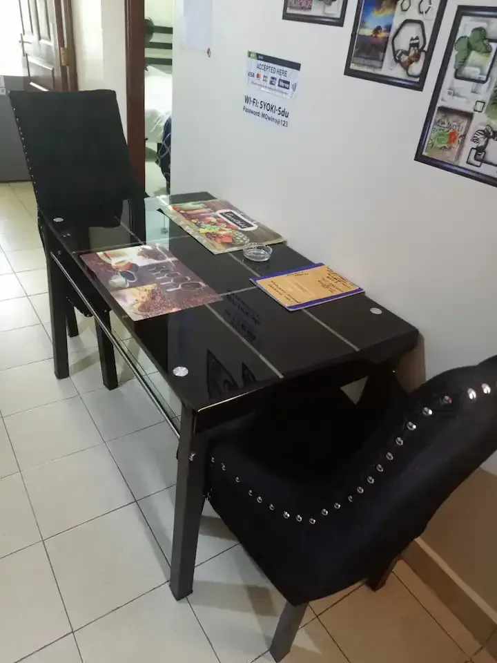 A black table and chairs in a room with pictures on the wall
