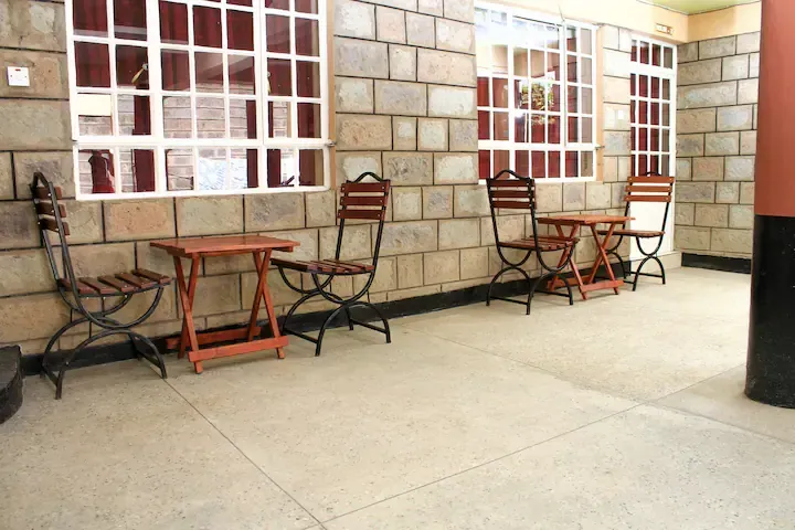A brick wall with tables and chairs in front of it