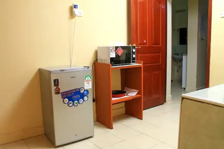 There is a small refrigerator and a microwave in the room.