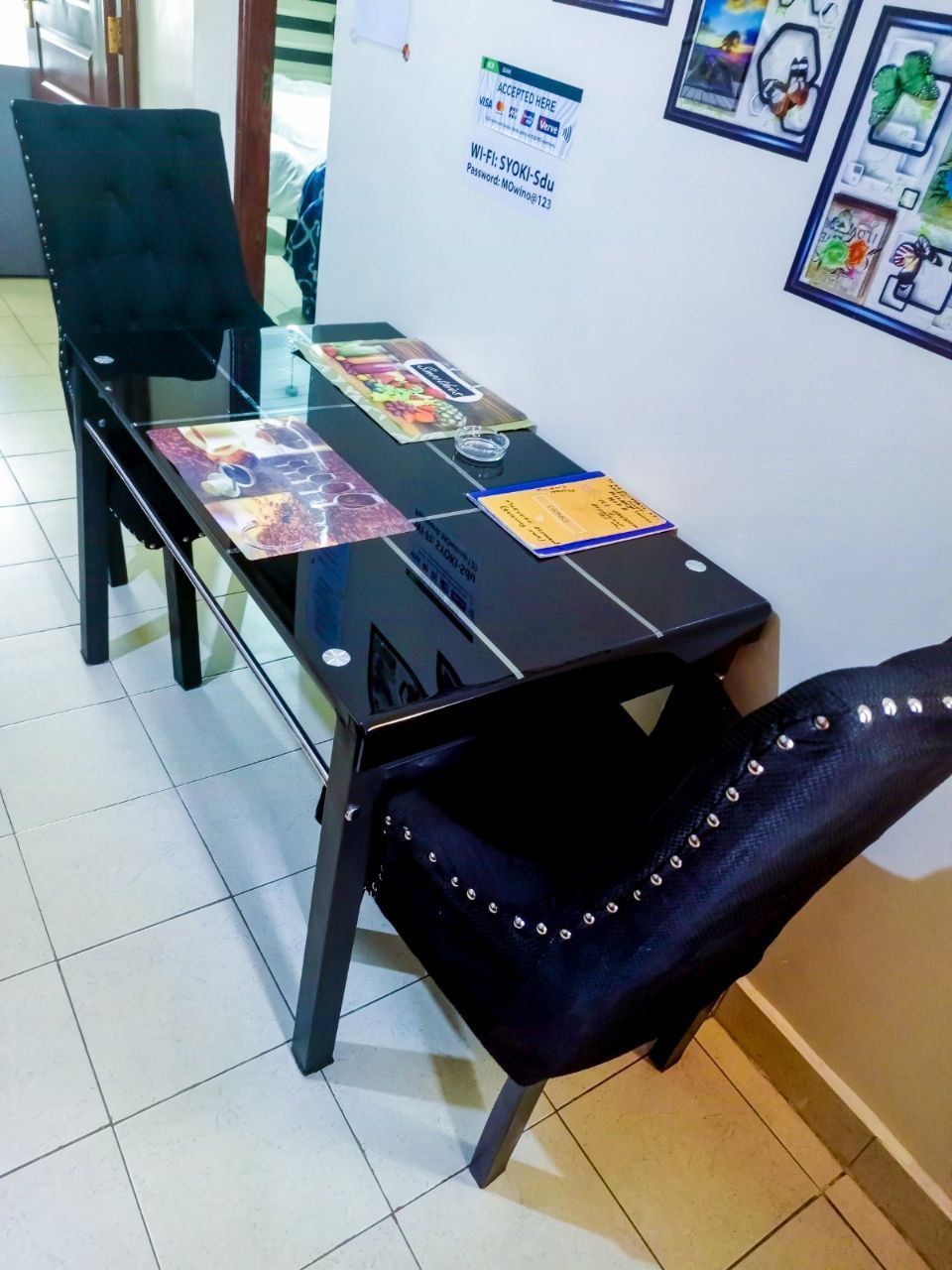A black chair sits next to a glass table