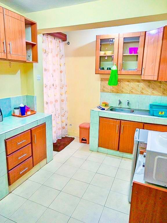 A kitchen with wooden cabinets and a microwave