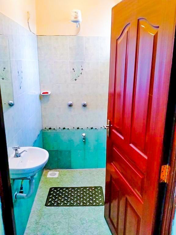 A bathroom with a sink and a red door.