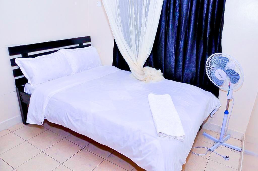 A bedroom with a bed and a fan in it.