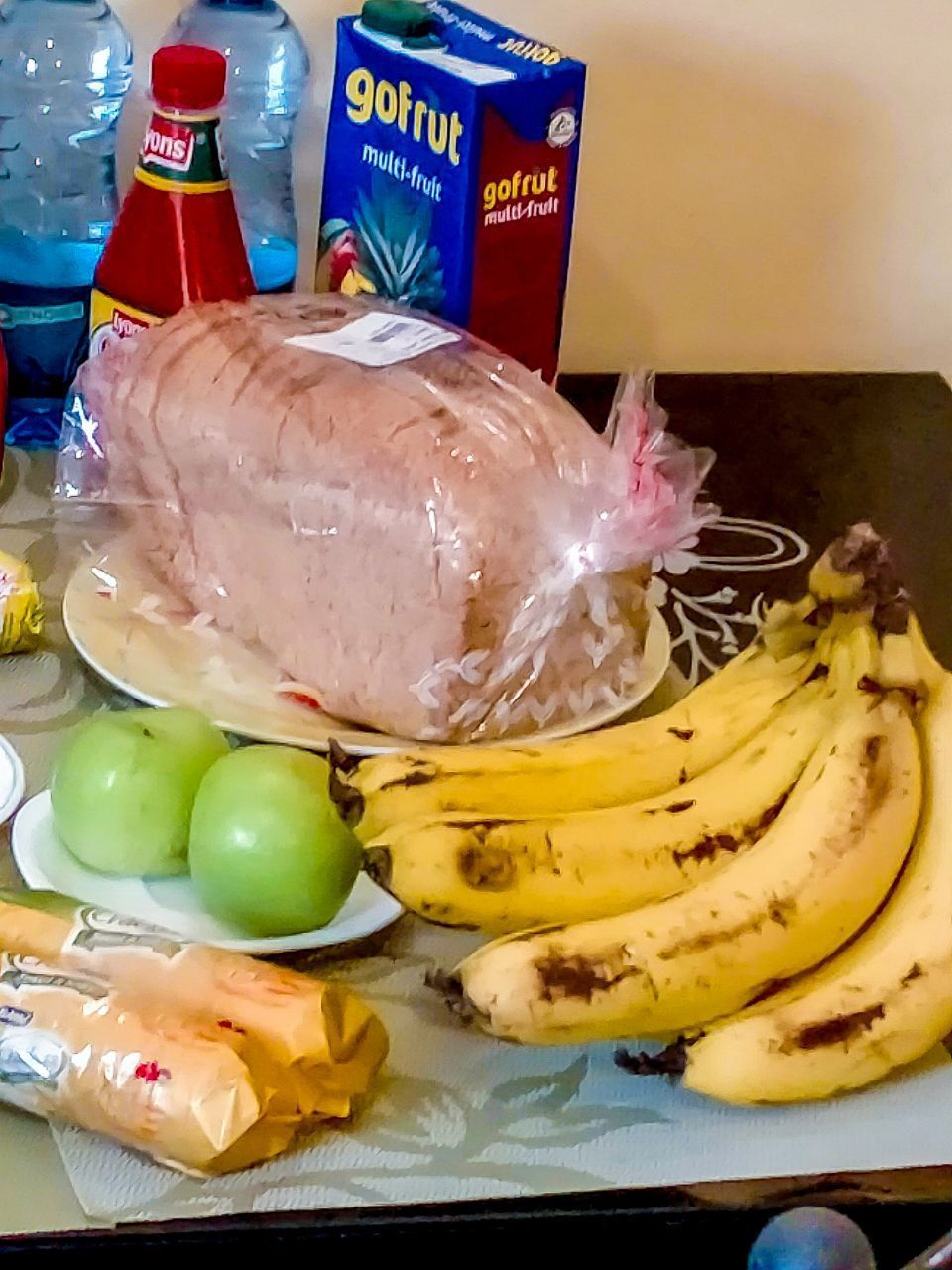 A box of gofruit sits on a table next to bananas