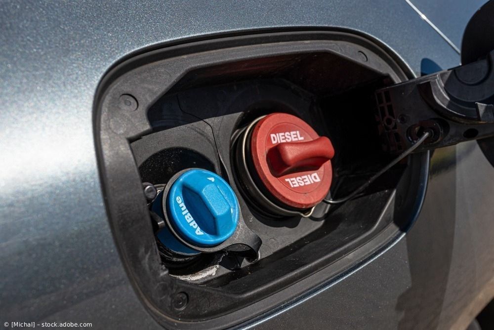Nahaufnahme von blauen und roten Tankdeckeln im Tankeinfüllstutzen eines Autos