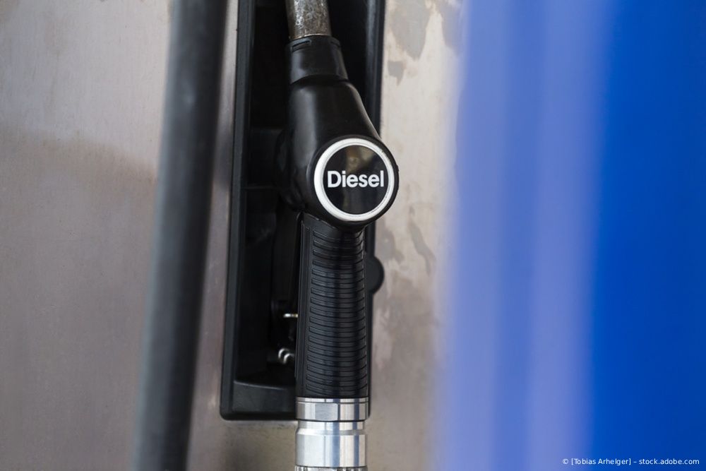 Dieselzapfpistole mit schwarzem Griff an einer Zapfsäule neben einem blauen Bedienfeld