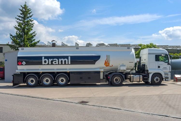 Ein weißer Tankwagen mit „braml“-Logo parkt draußen unter blauem Himmel
