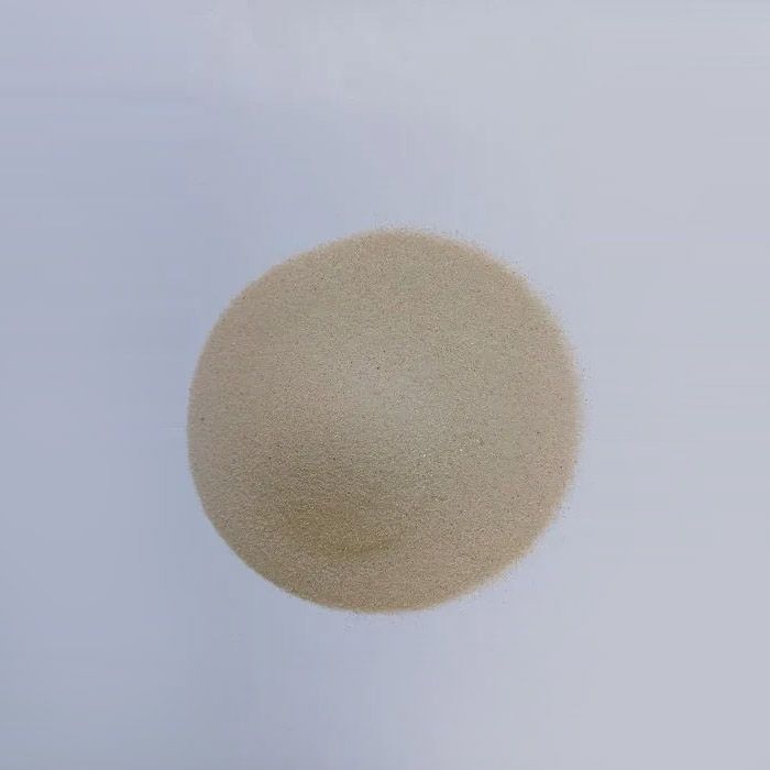 Montón circular de gránulos finos de color bronce sobre un fondo blanco.