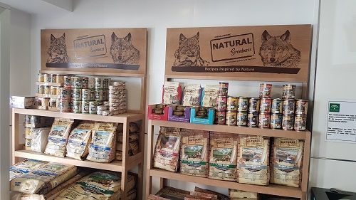 Una tienda llena de estantes llenos de bolsas de comida para perros.