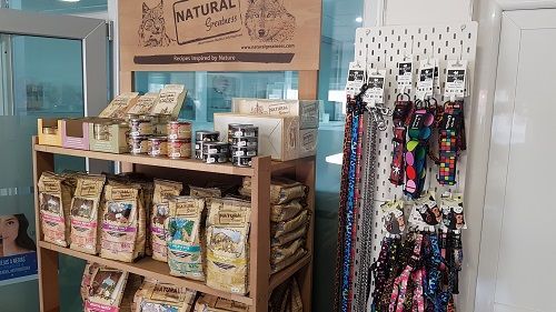 Un estante lleno de comida y collares para perros.