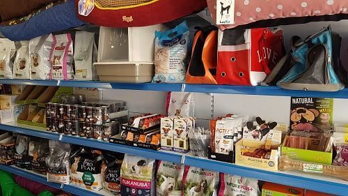 Un estante lleno de comida y juguetes para perros.