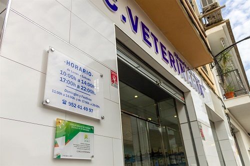 El exterior de una clínica veterinaria con un cartel en el costado del edificio.