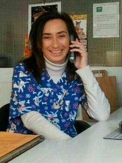Una mujer con una blusa azul está hablando por un teléfono celular.