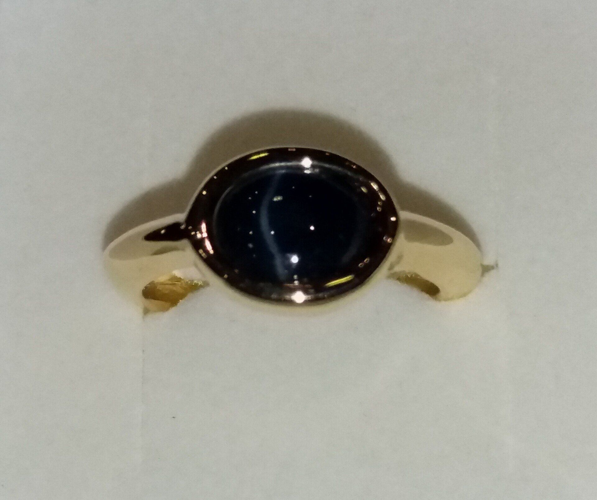 Une bague en or avec une pierre noire.