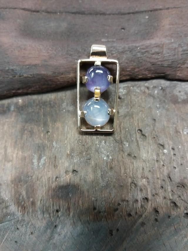 Un pendentif avec deux boules bleues.