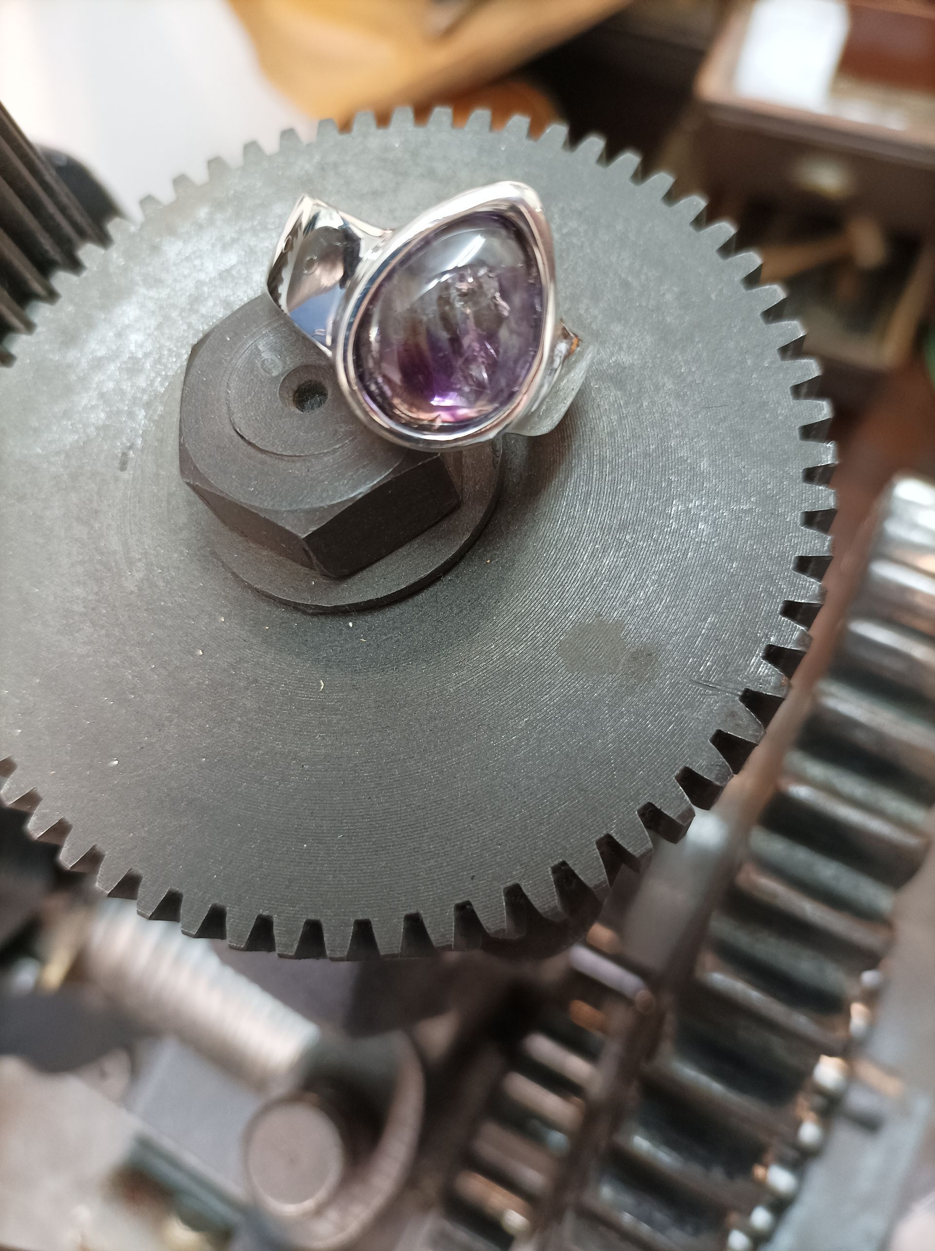 Une bague en argent avec une pierre violette dessus.