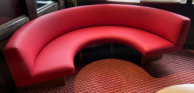 Ein ordentlich gemachtes Bett mit weisser Bettwäsche, einer blauen Tagesdecke und einem Zierkissen.