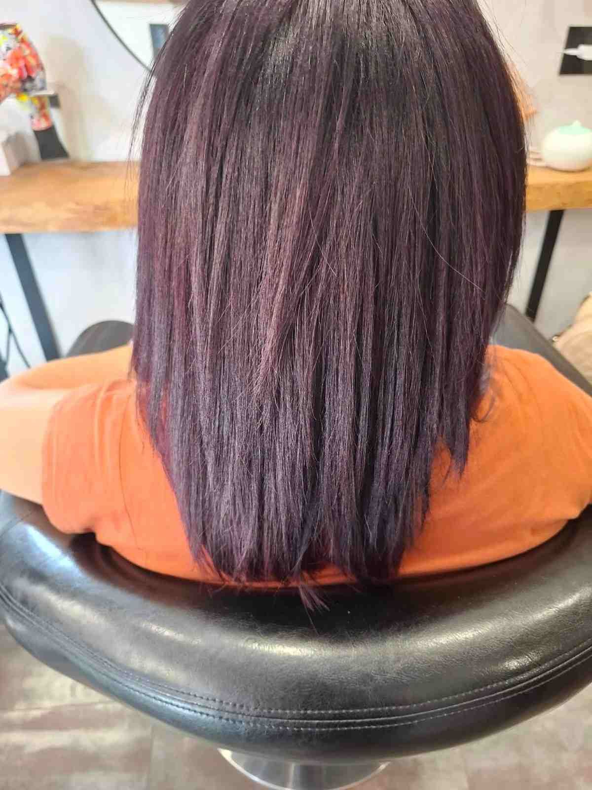 Vista trasera de una mujer con cabello morado oscuro