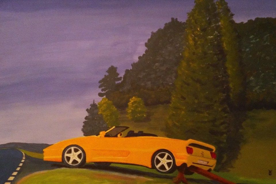 Gelbes Cabriolet auf einer Straße in der Nähe von Bäumen unter bewölktem Himmel.