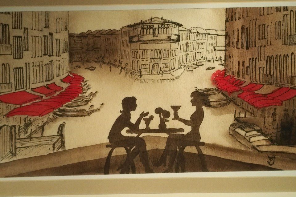 Silhouetten von Gestalten an einem Café-Tisch mit Blick auf eine europäische Stadtlandschaft mit roten Markisen.