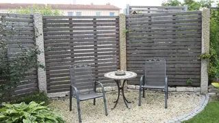 Kleine Terrasse mit hohem Holzzaun