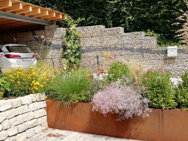 Blumenbeet mit einer Laterne und Steinen