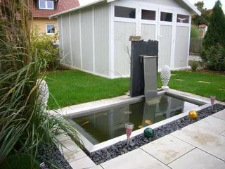 Gartenteich und weißes Holzhaus