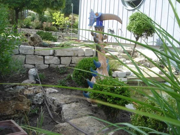 Teich und Mauer aus Naturstein in einem Garten