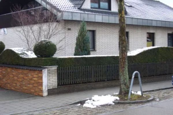 Haus mit Holzzaun und einer niedrigen Mauer