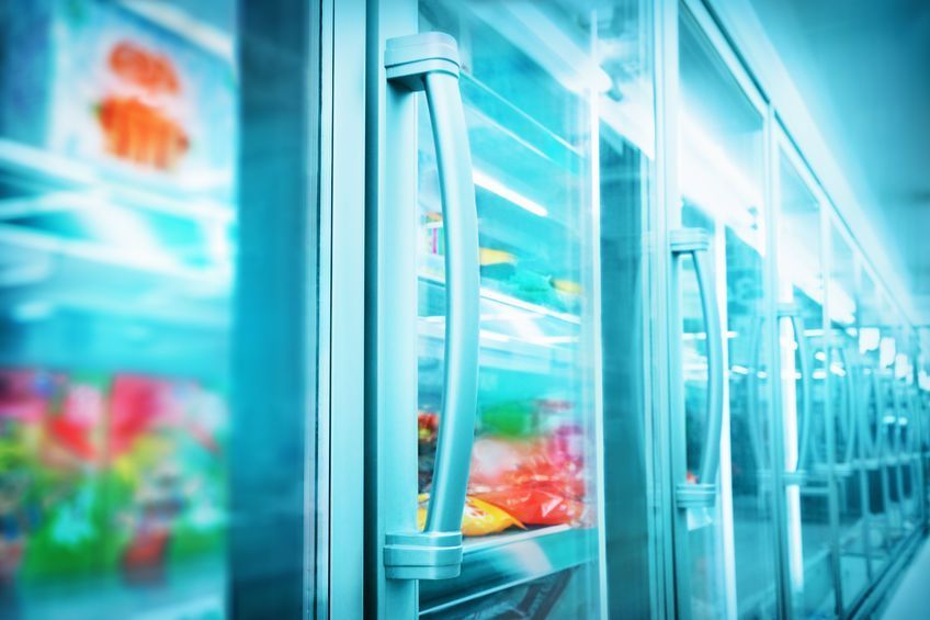 Una fila de refrigeradores con puertas de cristal en un supermercado.