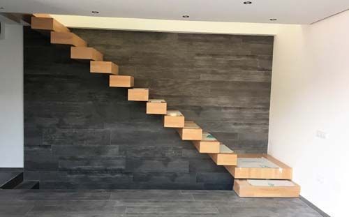 Una escalera de madera que sube por la pared de una habitación.
