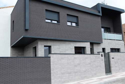 Una casa moderna con una valla delante de ella.