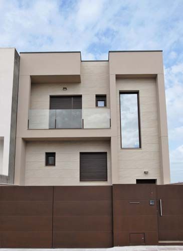 Una casa moderna con una valla marrón a su alrededor.