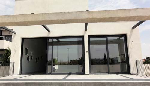 Una casa blanca con muchas ventanas y un dosel.