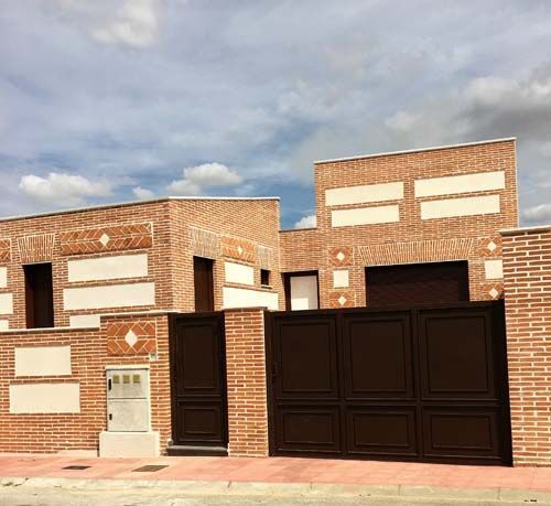 Un edificio de ladrillos con una puerta de garaje marrón.