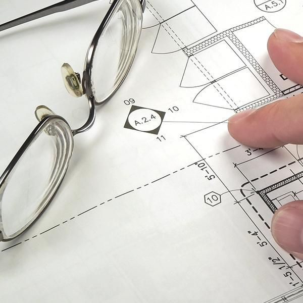 Un par de gafas se encuentran encima de un dibujo de una casa.