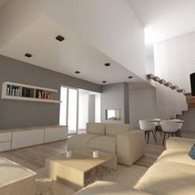 Una sala de estar con sofá, mesa, sillas y escaleras.