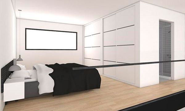 Un dormitorio con una cama grande y una pared blanca.