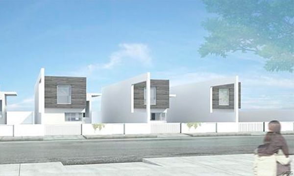 Una mujer camina por una acera frente a una hilera de casas.