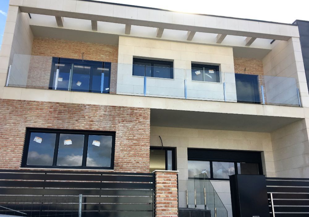 Una casa grande con barandilla de cristal y escaleras.