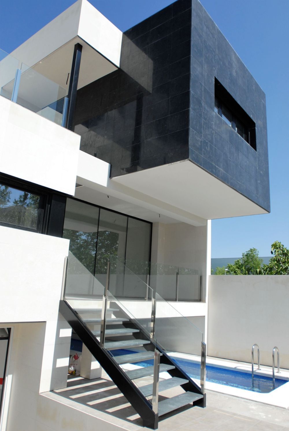 Una casa moderna con escaleras que conducen a una piscina.