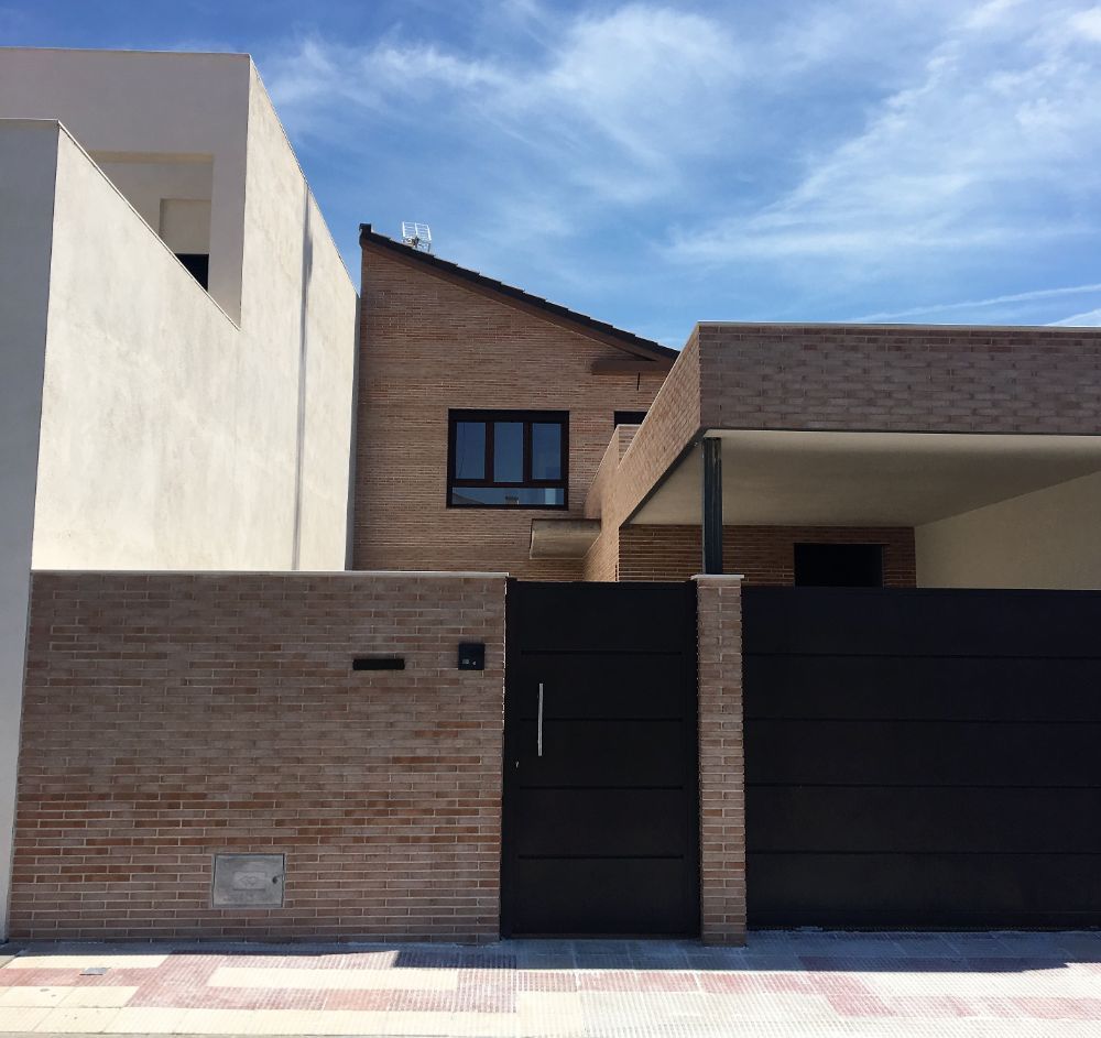 Una casa de ladrillo con una puerta negra delante.