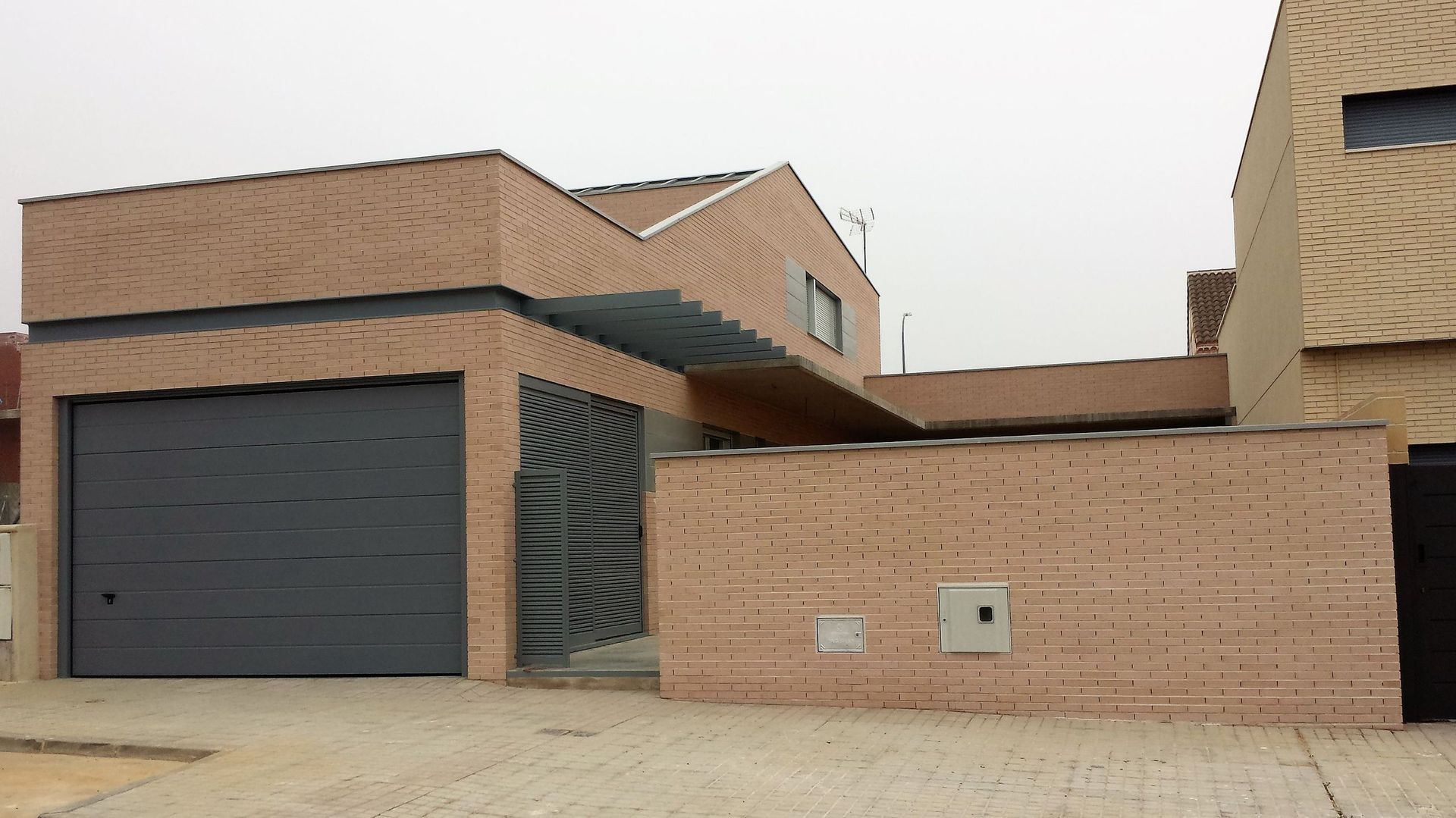 Una casa con garaje y pared de ladrillo.