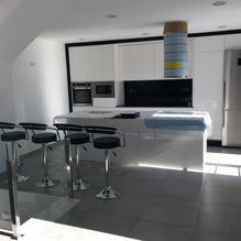 Una cocina con taburetes y una gran isla en el medio de la estancia.