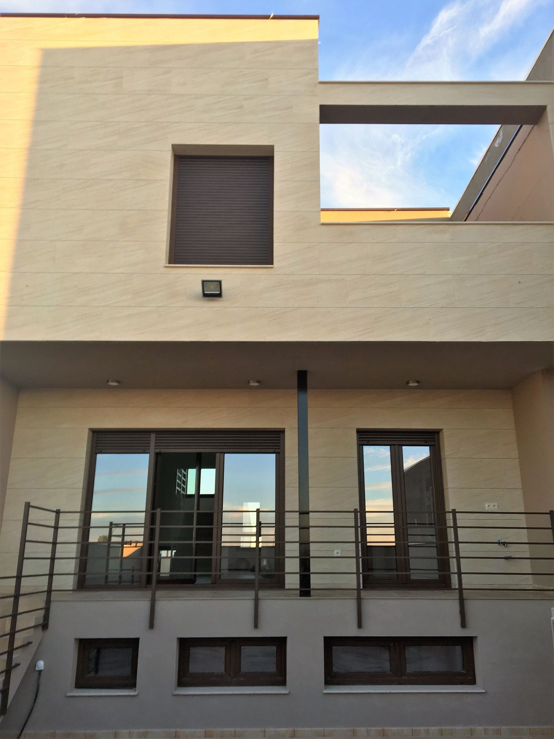 Una casa con balcón y puertas corredizas de vidrio.