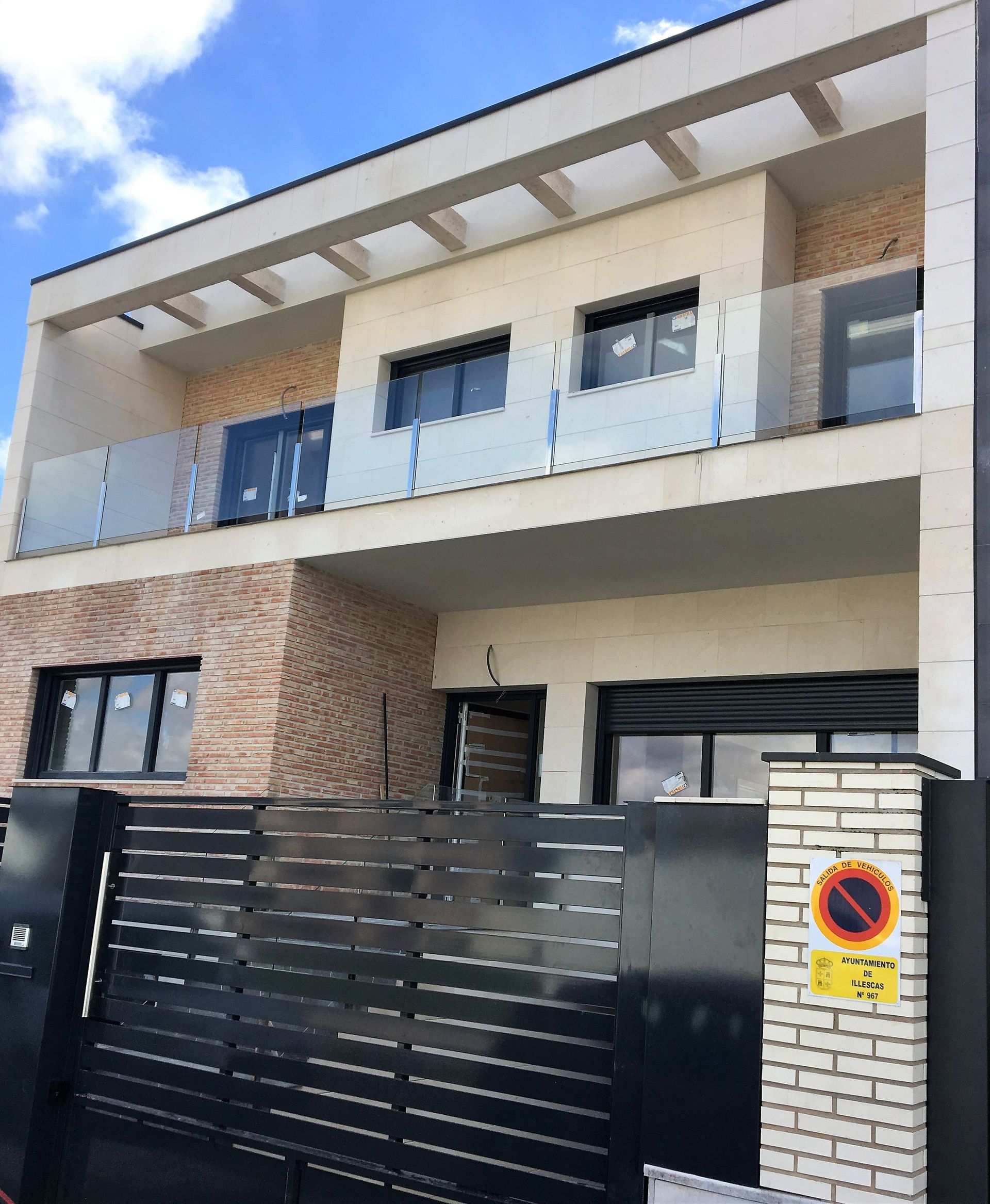 Una casa con un cartel de no estacionar al costado.