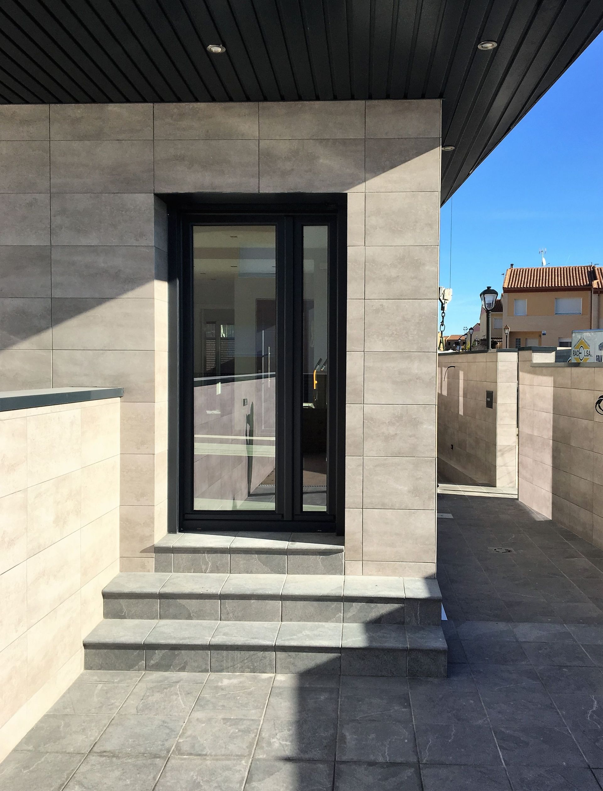 Un edificio con una puerta corrediza de vidrio y escaleras.
