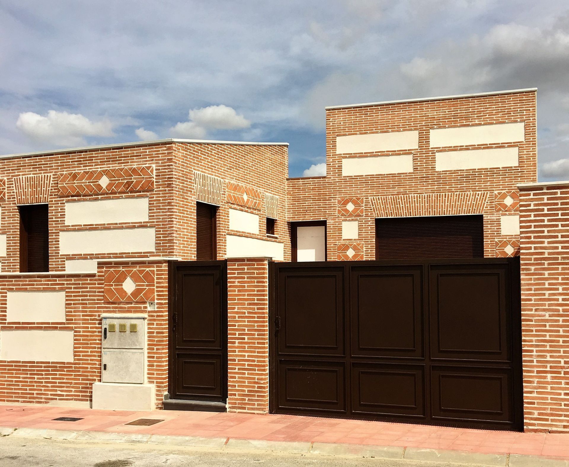 Un edificio de ladrillo con una puerta marrón delante.